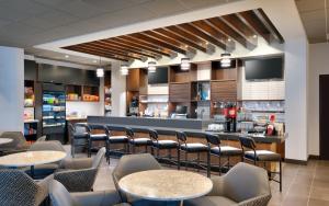 a kitchen filled with lots of tables and chairs at Hyatt Place Anchorage-Midtown in Anchorage