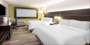 a hotel room with two beds and a flat screen tv at Holiday Inn Express & Suites - Greenville - Taylors by IHG in Greenville