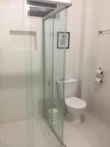een badkamer met een toilet en een glazen douche bij Hotel Miranelli in Barbacena