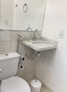a bathroom with a white toilet and a sink at Hotel Miranelli in Barbacena