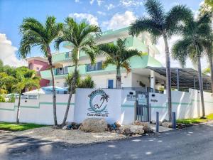 un edificio con palmeras delante en Casa Verde Hotel en Rincon