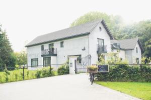 a white house with a bike parked in front of it at Bed and breakfast Mooi Achel in Achel