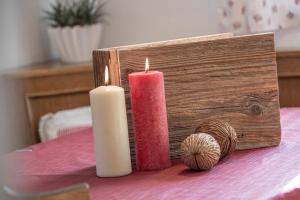 zwei Kerzen auf einem Tisch neben einer Holzkiste in der Unterkunft Turnerhof in Brixen