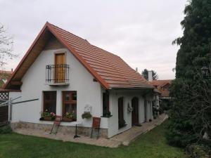 een wit huis met een rood dak bij Sziget Vendégház in Kőszeg