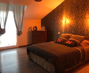 een slaapkamer met een groot bed en een raam bij l appart de Lilly in Pierry