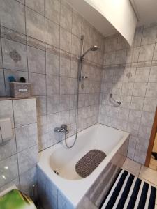 een badkamer met een bad en een douche bij R&A Lambertz in Düsseldorf