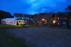eine Gruppe von Menschen, die nachts vor einem Gebäude stehen in der Unterkunft Camping Fox Český Krumlov in Kájov