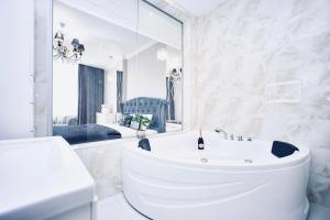ein weißes Badezimmer mit einem Waschbecken und einem Spiegel in der Unterkunft Panoramic Plaza Apartments in Odessa