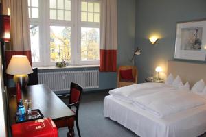 a hotel room with a bed and a table and window at Hotel Drei Kronen in Lippstadt