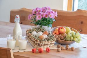 una mesa cubierta con una cesta de fruta y una botella de leche en Turnerhof, en Bresanona