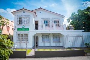 a white house with a fence in front of it at Hotel Casa Branca in Uruguaiana