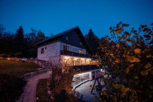 a house with lights on it at night at Golden Lakes Rooms in Plitvička Jezera