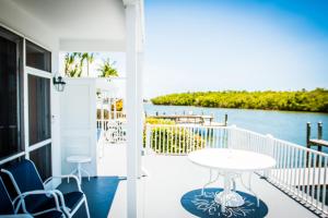 a balcony with a table and chairs and a view of the water at The BoatHouse in Marco Island