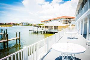 a balcony with tables and a view of the water at The BoatHouse in Marco Island