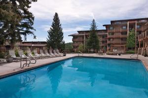 a swimming pool at a hotel with chairs and a building at Stonebridge Inn in Snowmass Village