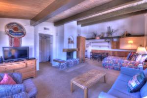 uma sala de estar com um sofá, uma televisão e uma mesa em Aspenwood - CoralTree Residence Collection em Snowmass Village
