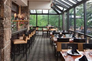 um restaurante com mesas, cadeiras e janelas em Stonebridge Inn em Snowmass Village