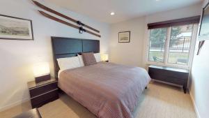 a bedroom with a large bed and two windows at Lichenhearth - CoralTree Residence Collection in Snowmass Village