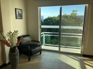 sala de estar con silla y ventana grande en San Pedro Hotel, 5ta Avenida en Playa del Carmen