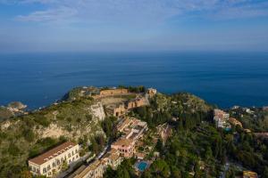 una vista aerea di una città su una collina vicino all'oceano di Le Jardin Romain a Taormina