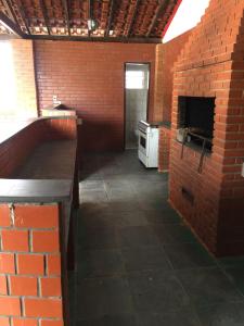 a kitchen with a brick wall and a brick oven at Chácara Paraíso de Itamonte MG in Itamonte