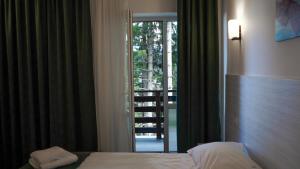 a bedroom with a bed and a door to a balcony at Hotel Cirus in Predeal