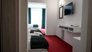 a hotel room with two beds and a red carpet at Hotel Cirus in Predeal