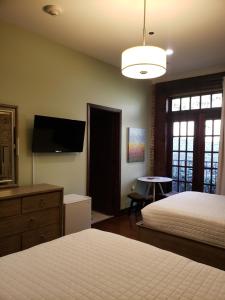 a bedroom with two beds and a flat screen tv at Hotel Hale in Hot Springs