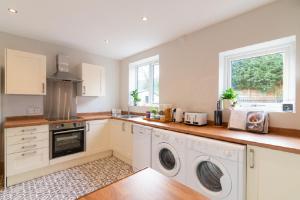 a kitchen with a washer and dryer on a counter at Beautiful 6 Bedroom Holiday Home, Manchester in Wythenshawe