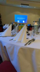 ein Tisch mit weißen Servietten und Gläsern darauf in der Unterkunft Hotel Drei Kronen in Lippstadt