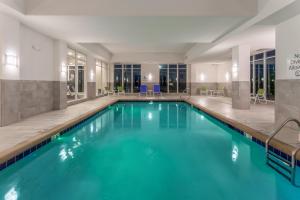 Holiday Inn & Suites - Jefferson City, an IHG Hotel في جيفرسون سيتي: حمام سباحة بمياه زرقاء في غرفة في الفندق
