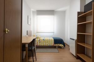 サンティアゴ・デ・コンポステーラにあるPR Nimoのベッドルーム1室(ベッド1台、デスク、テーブル付)