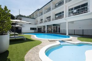 a swimming pool in front of a building at Hotel Armitage and Conference Centre in Tauranga