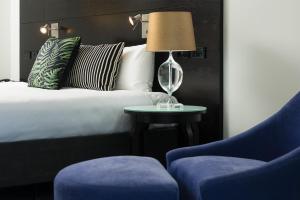 a bedroom with a bed and a table and a chair at Mercure Tauranga in Tauranga