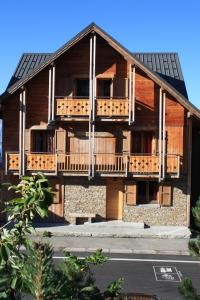 ラルプ・デュエズにあるChalet Grande Etoile des Neigesの木製バルコニー付きの大きな木造家屋