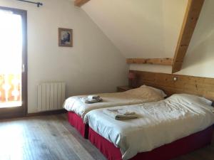 sypialnia z 2 łóżkami na poddaszu w obiekcie Chalet Grande Etoile des Neiges w LʼAlpe-dʼHuez
