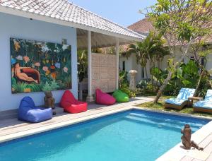 a pool with colorful pillows next to a house at Starling villas in Sanur