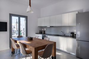 una cucina con tavolo in legno e alcune sedie di Parikia's Crossroad 3 Bedroom House a Kampos Paros