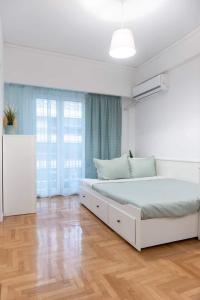 ein Schlafzimmer mit einem weißen Bett und einem großen Fenster in der Unterkunft Apartment one breath from Acropolis in Athen
