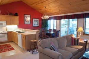 a kitchen and living room with a couch and a table at JHRL - Teton Pines Townhome #20 in Wilson
