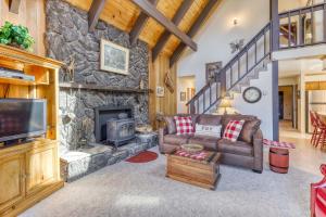a living room with a couch and a stone fireplace at Tallac Views Getaway in South Lake Tahoe