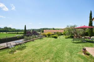 a yard with benches and tables and a fence at Casa VolaTerrA in Volterra