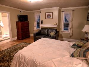 Onemo的住宿－Foster's Bethel Beach Inn，一间卧室配有一张床、一张沙发和一把椅子