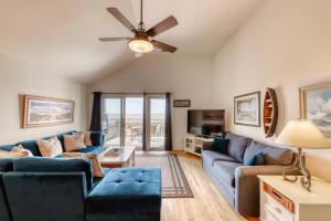 a living room with blue couches and a ceiling fan at 1378 Pelican Watch Villa in Seabrook Island