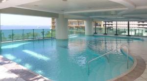 ein großes Schwimmbecken mit blauem Wasser in einem Gebäude in der Unterkunft Baywatch Tower in Manila