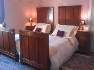 a bedroom with a large bed with a wooden headboard at White Lady B&B in Monticelli dʼOngina