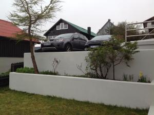 two cars parked on top of a retaining wall at Marna Guesthouse doubleroom nr.2 in Tórshavn