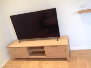 a flat screen tv sitting on top of a wooden entertainment center at Marna Guesthouse doubleroom nr.2 in Tórshavn