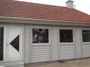a garage with two windows and a red roof at Marna Guesthouse doubleroom nr.2 in Tórshavn