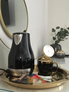 una macchinetta del caffè su un vassoio con uno specchio di MARZEC Apartamenty a Gniezno Altre 79 foto